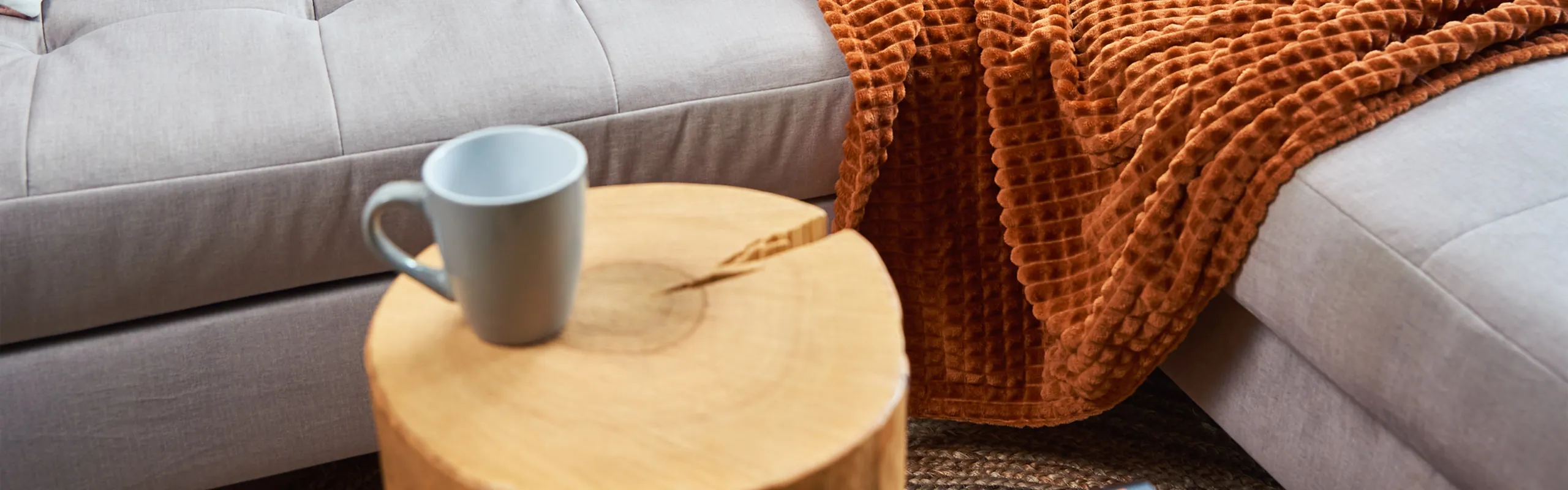 Couch with table and coffee and orange blanket