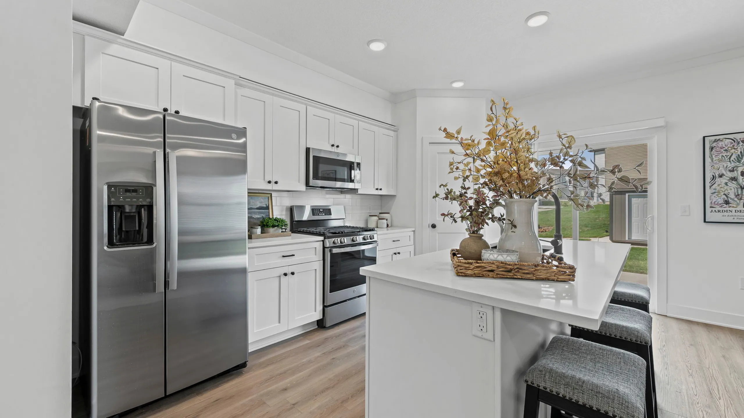 Modern kitchen with sleek stainless steel appliances, elegant white cabinetry, and a stylish island with seating.