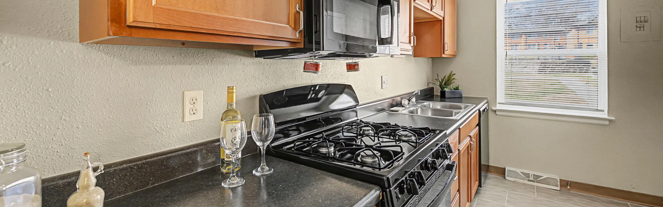 Charming kitchen with sleek granite countertops, modern appliances, and inviting natural light through the large window.