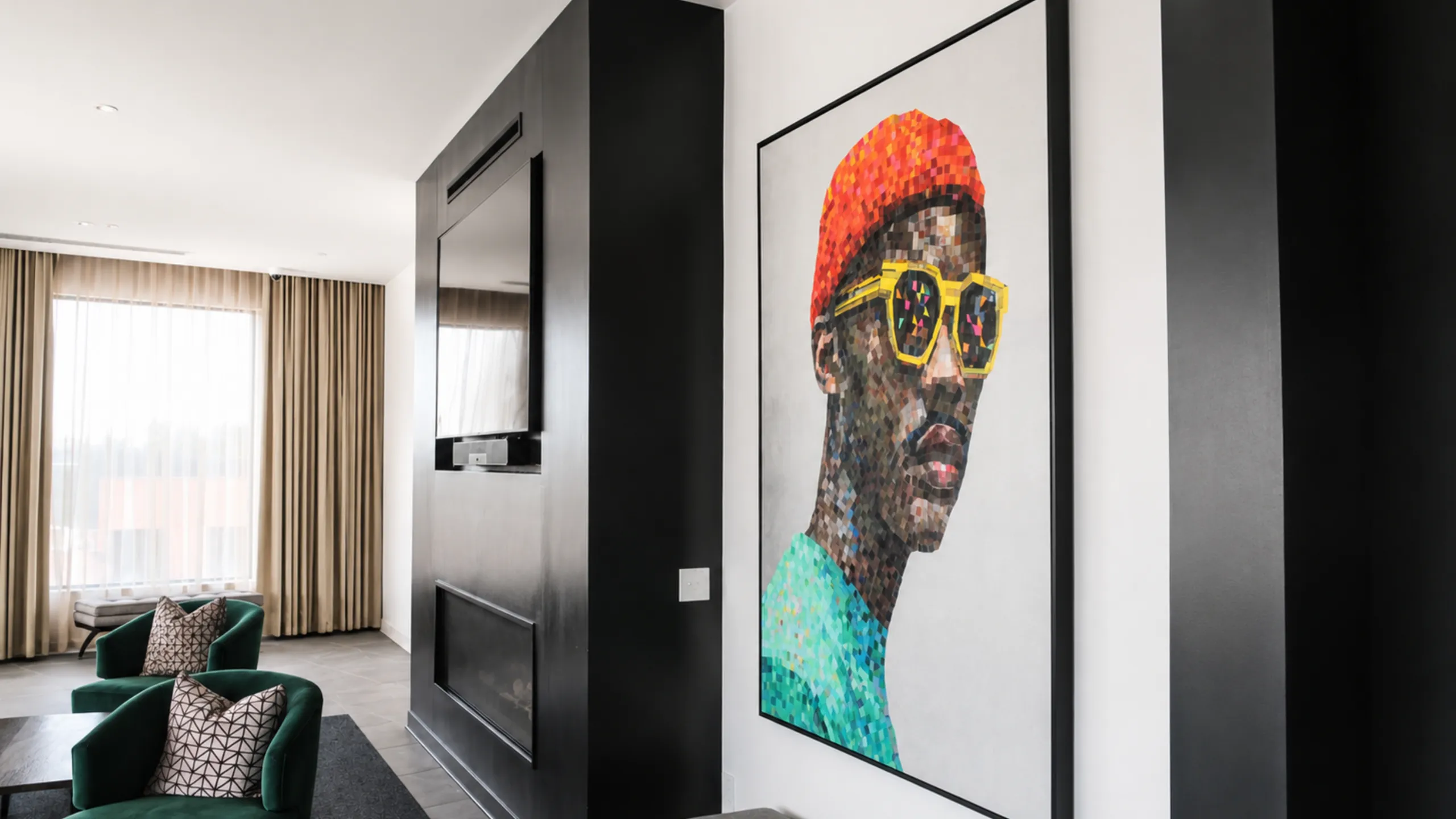 Contemporary living space with elegant decor, featuring vibrant artwork and plush green armchairs creating a cozy and stylish atmosphere.