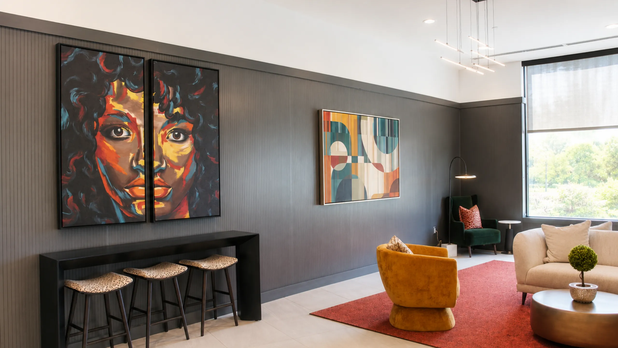 Chic modern living space with bold artistic paintings, elegant seating, and floor-to-ceiling windows offering natural light.
