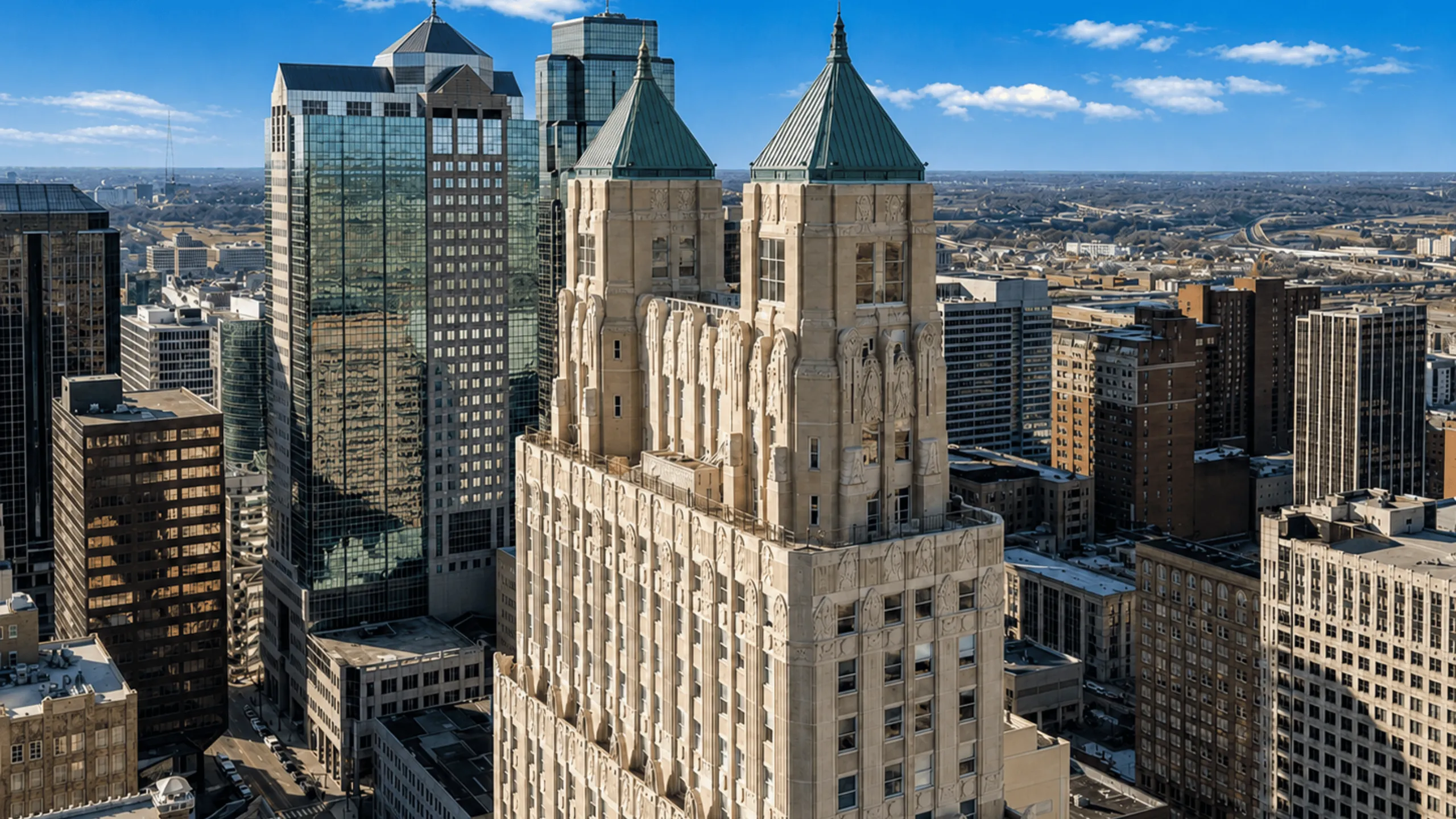 Stunning aerial view of a historic skyscraper with intricate architectural details, set against a vibrant cityscape under a clear blue sky.