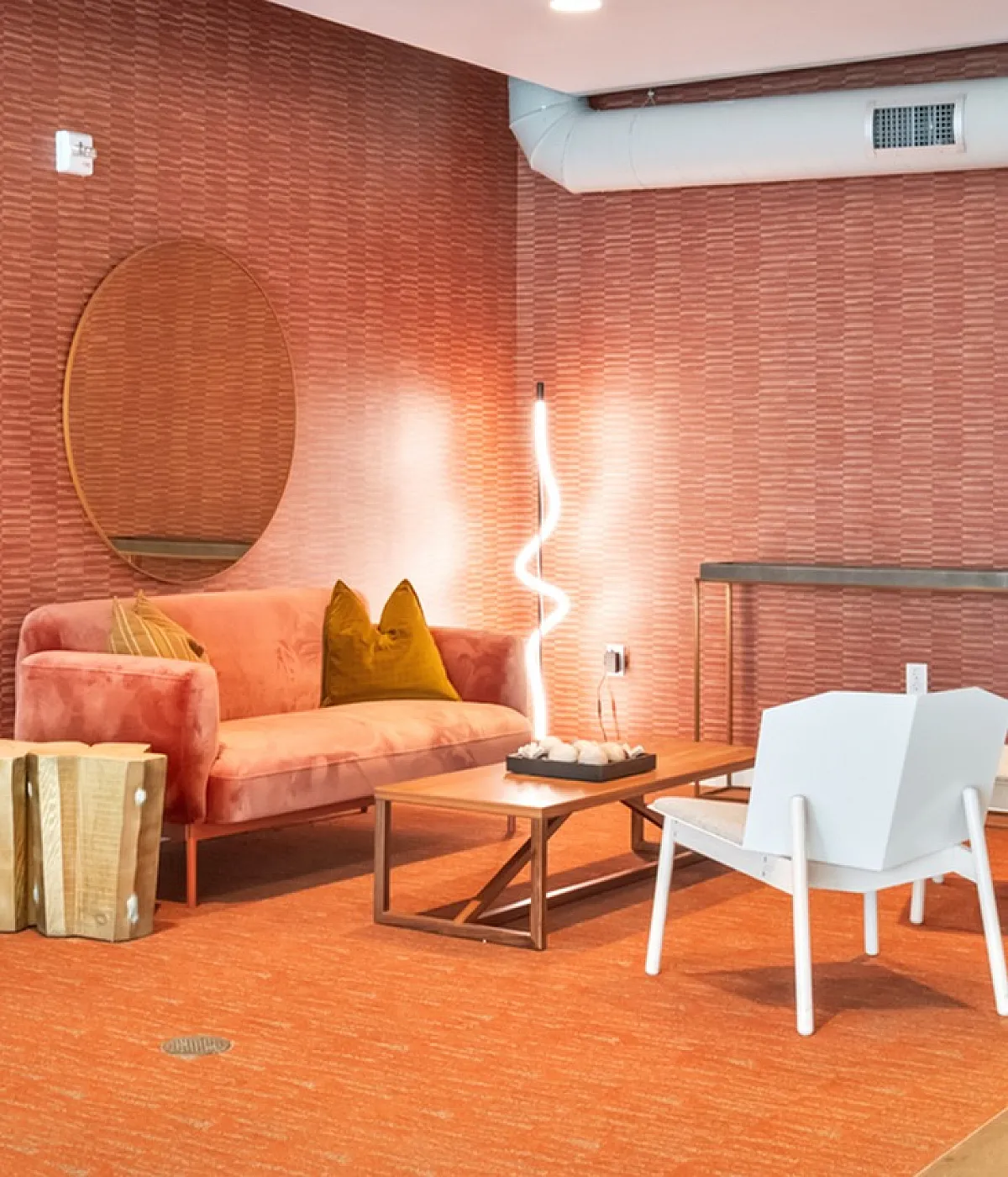 Modern lobby space with chic red textured walls, stylish seating, and ambient lighting perfect for relaxation.