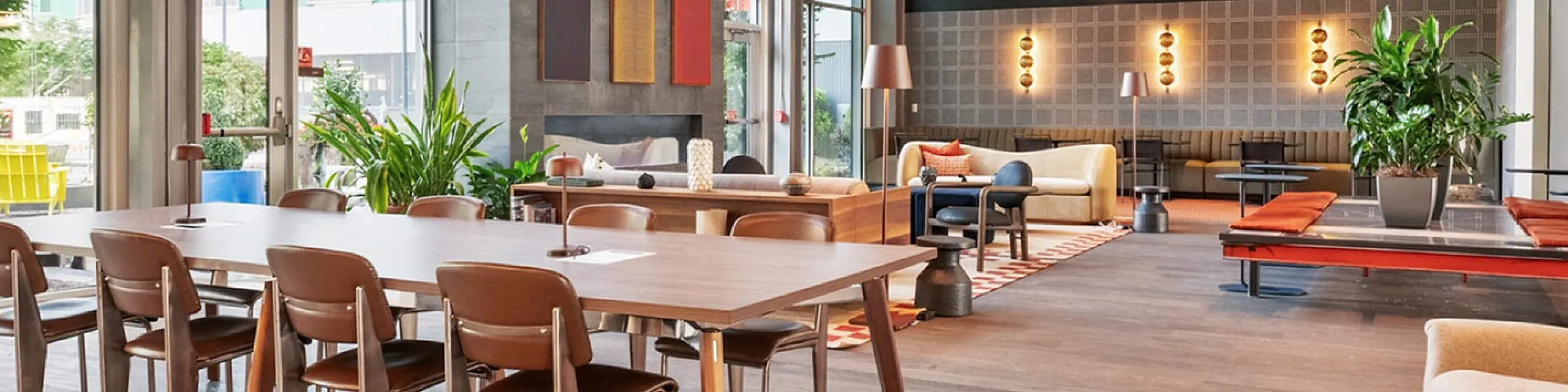Contemporary open-plan lobby with stylish seating, large windows for natural light, and elegant pendant lighting.