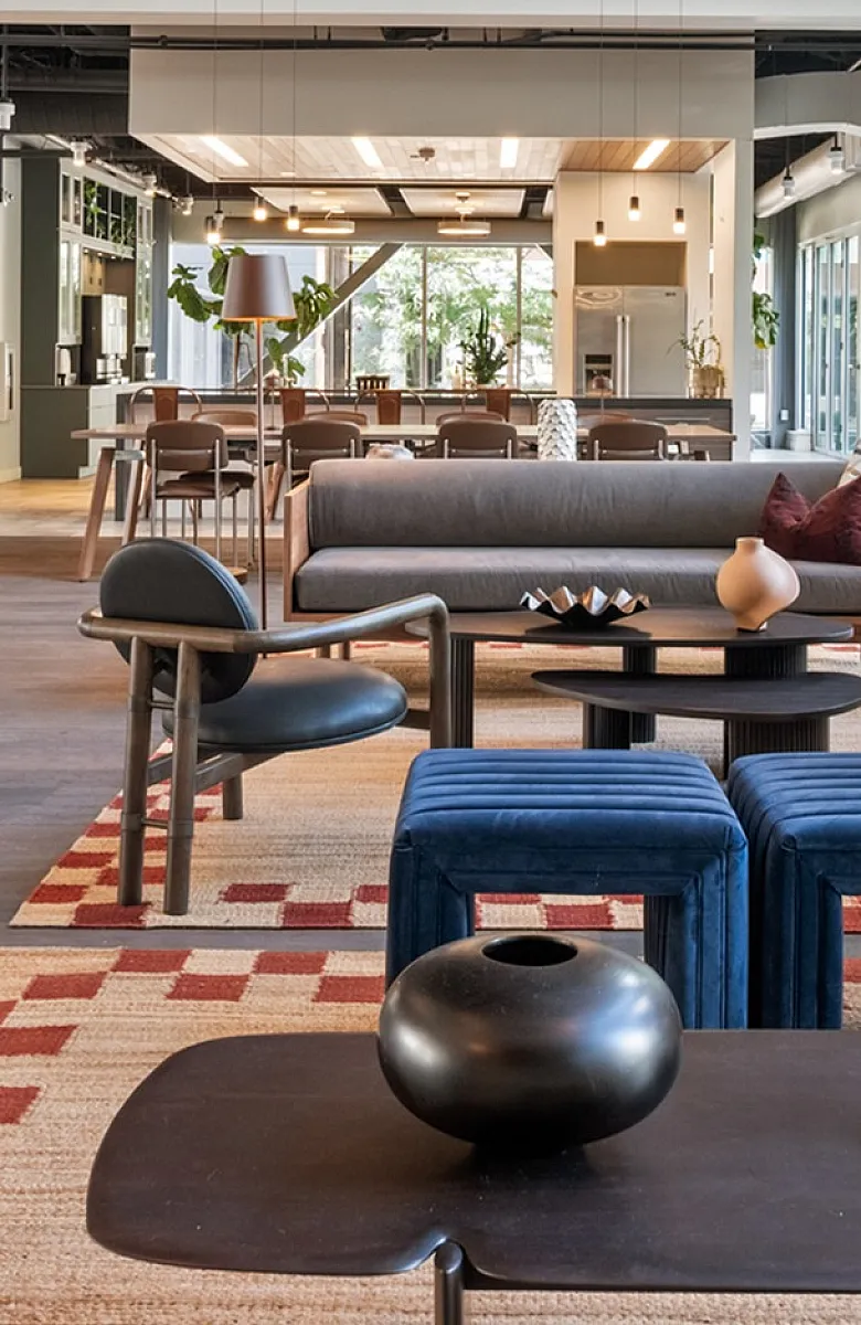Luxurious open-concept living space featuring modern furniture, colorful abstract artwork, and floor-to-ceiling windows with natural light.