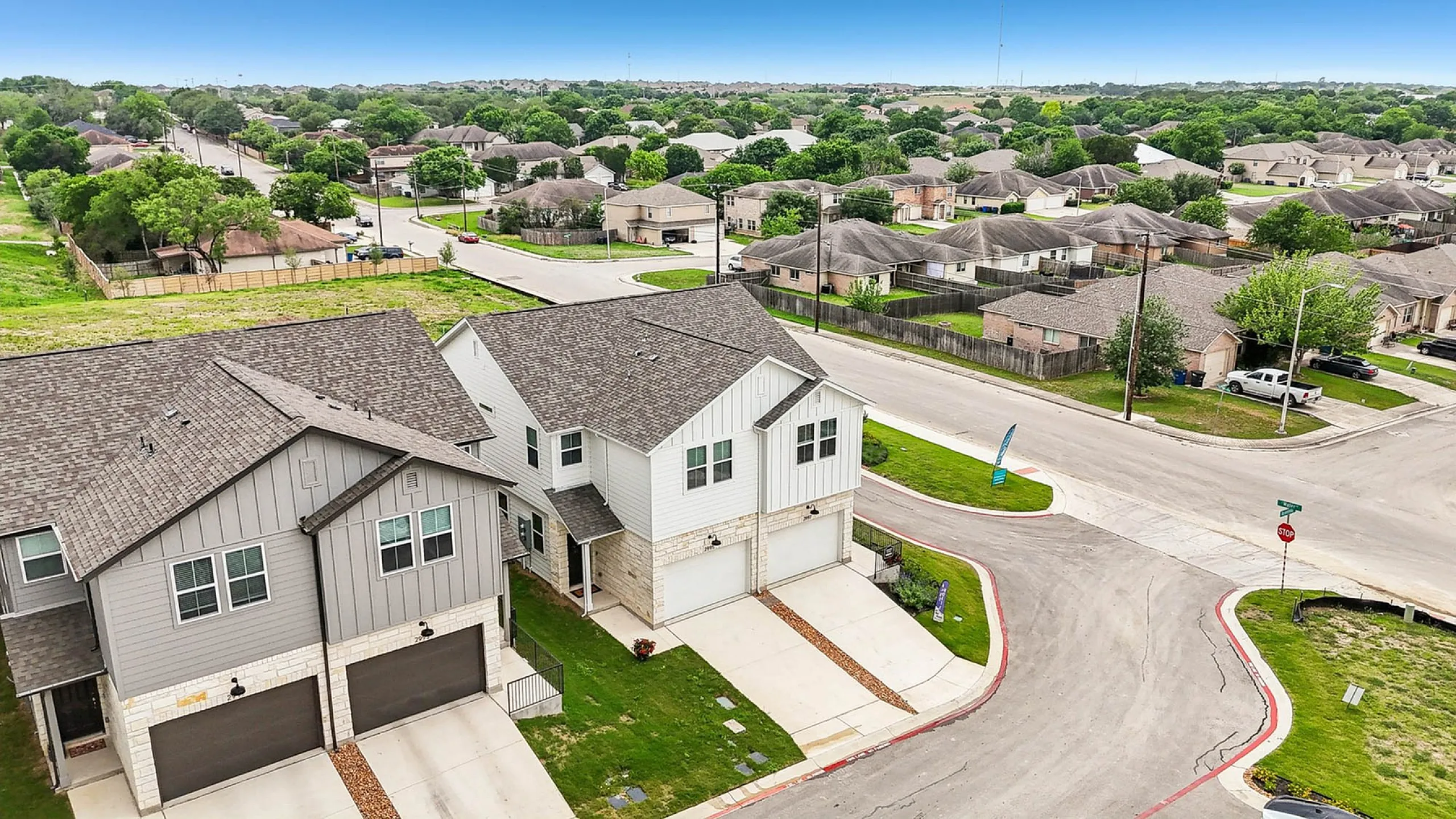 Charming aerial view of a modern suburban neighborhood with stylish homes, lush greenery, and well-maintained streets.