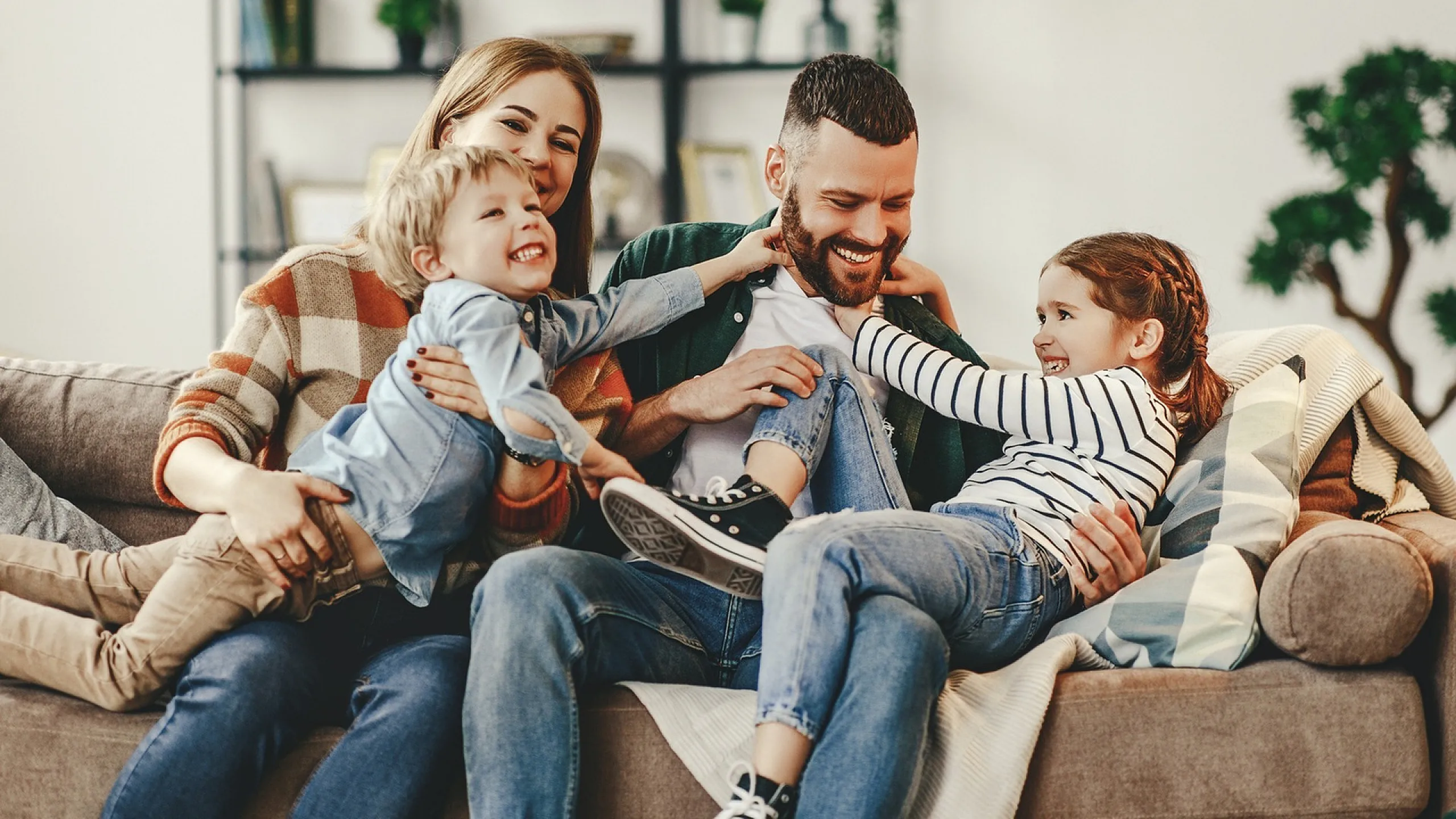 Happy family enjoying quality time together on a comfortable living room sofa, creating cherished memories in a cozy home setting.