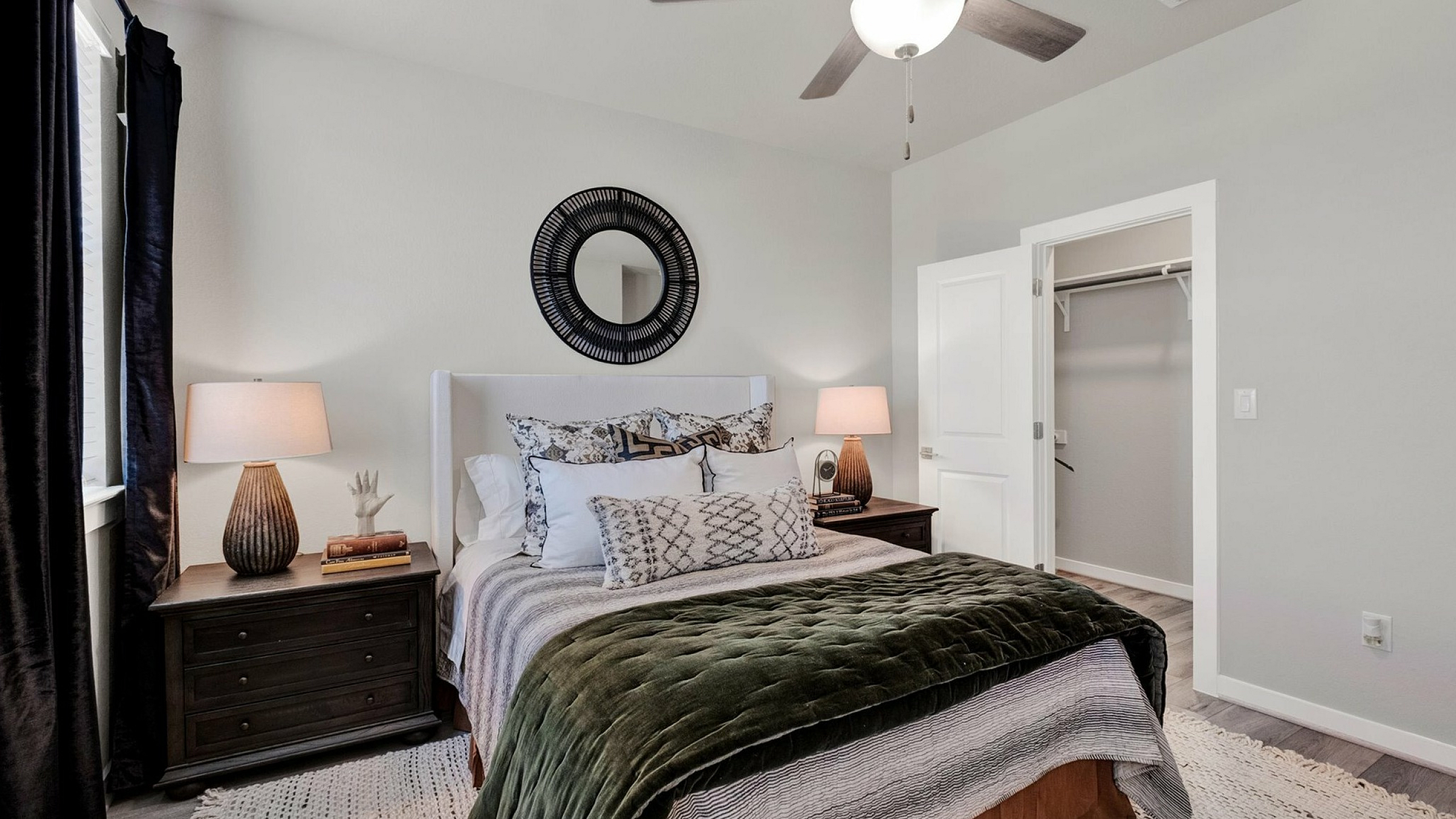 Inviting modern bedroom with elegant decor, featuring a plush bed, stylish nightstands, cozy lighting, and a decorative wall mirror.