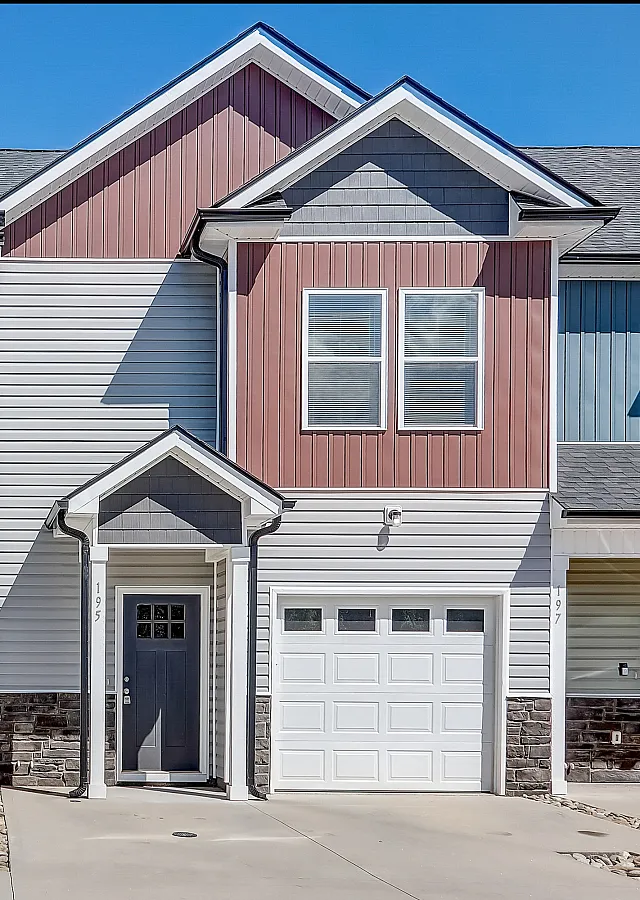 Charming townhouse facade with dual-toned siding and inviting front entryway.