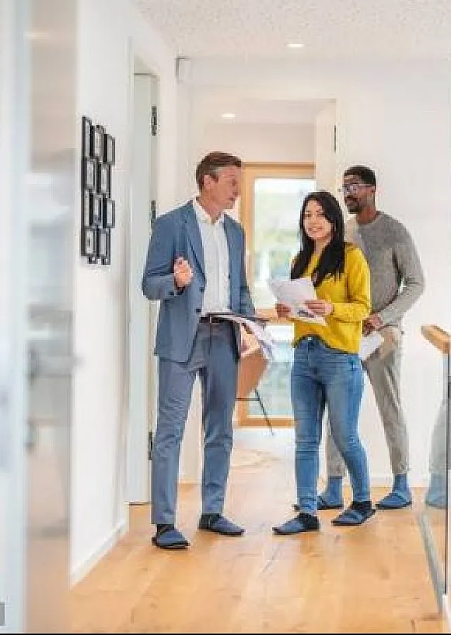 Inviting apartment hallway with wooden flooring, featuring a group touring a stylish and well-lit space.