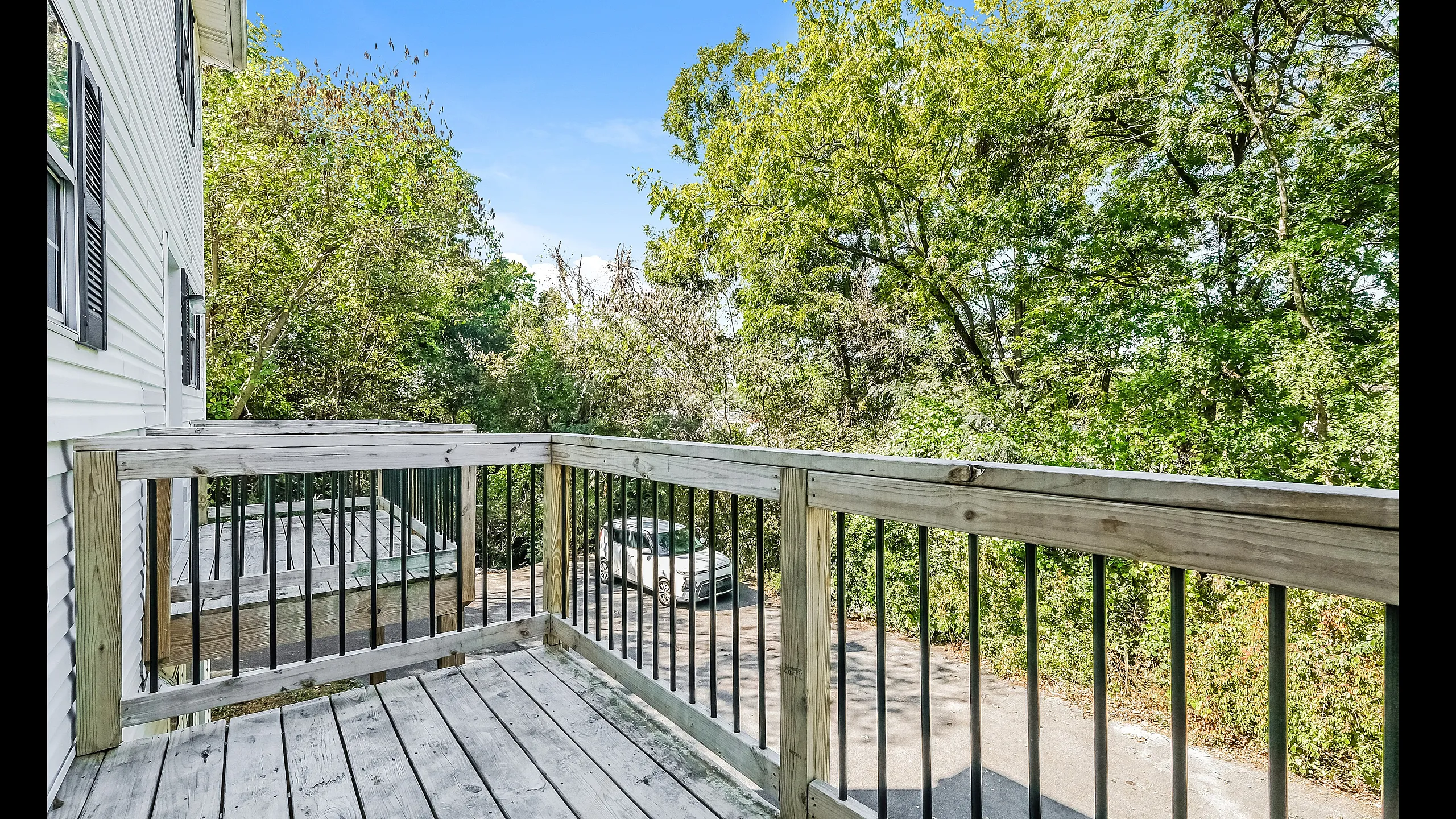 Inviting balcony overlooking lush green trees, providing a serene outdoor space for relaxation.