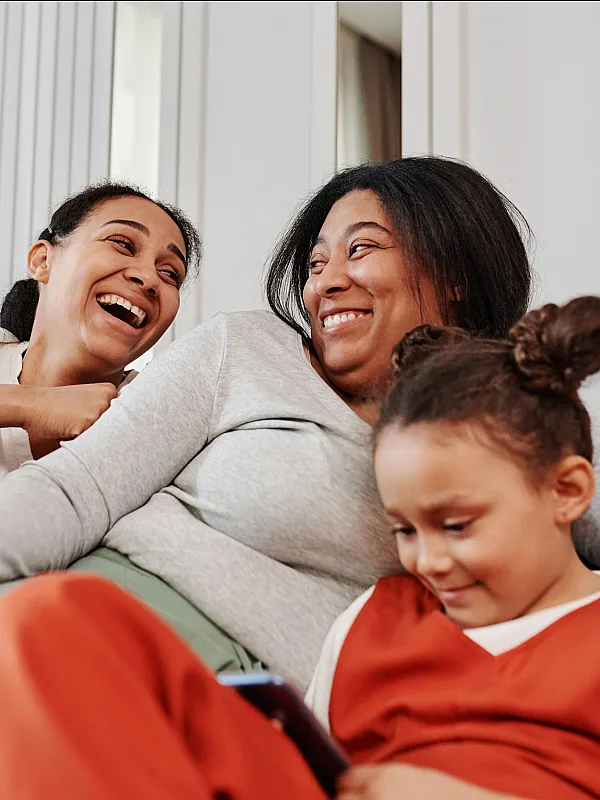 Happy family enjoying quality time together on a cozy gray sofa in a bright and welcoming living room.