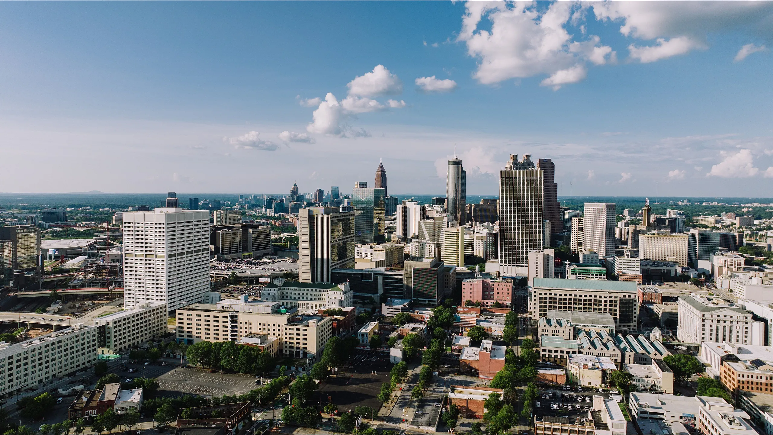 Spectacular aerial view showcasing a vibrant city skyline with a mix of modern skyscrapers and historic architecture under a bright blue sky.