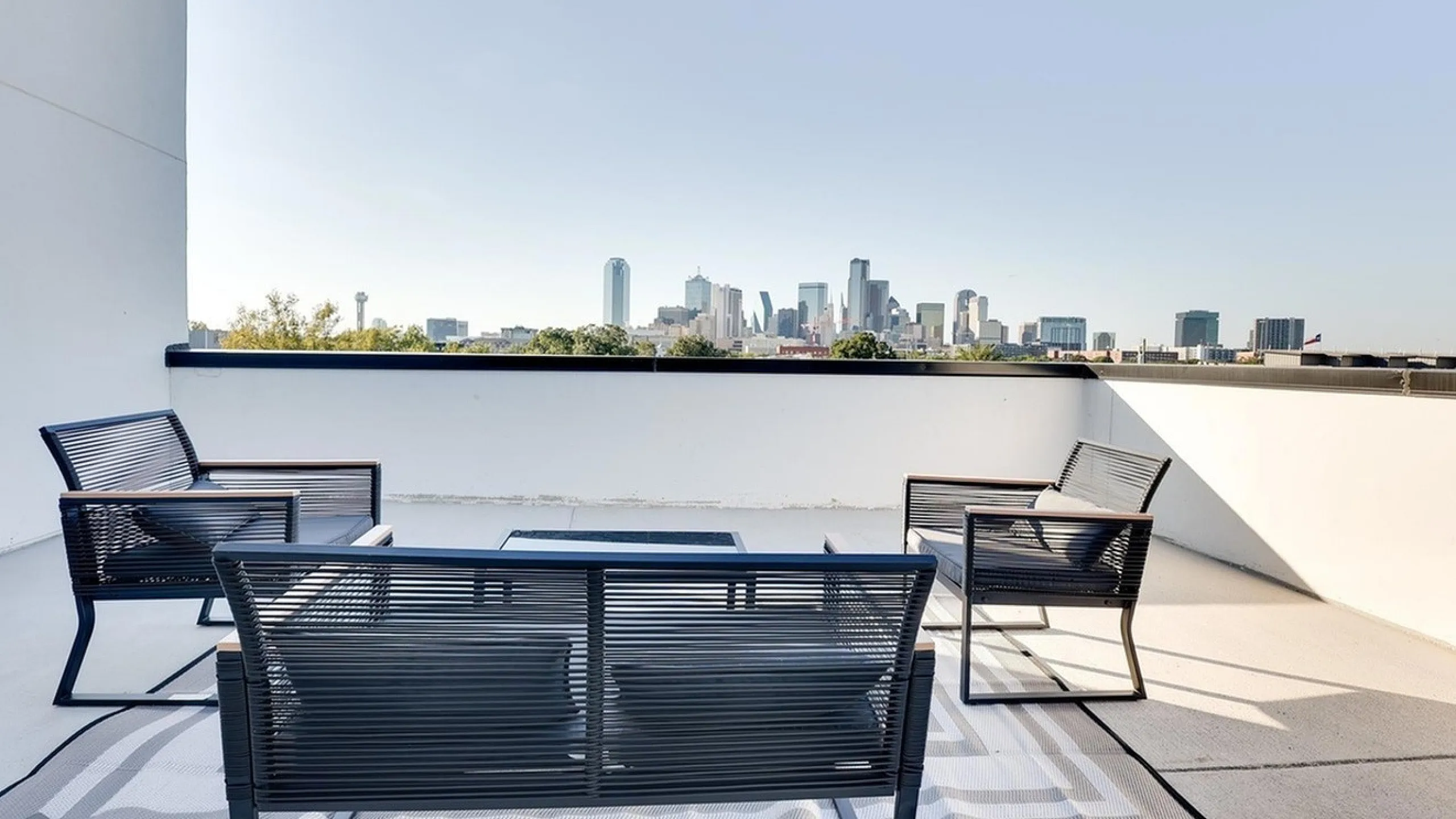 Chic balcony offering stunning city skyline views, complete with modern outdoor seating.