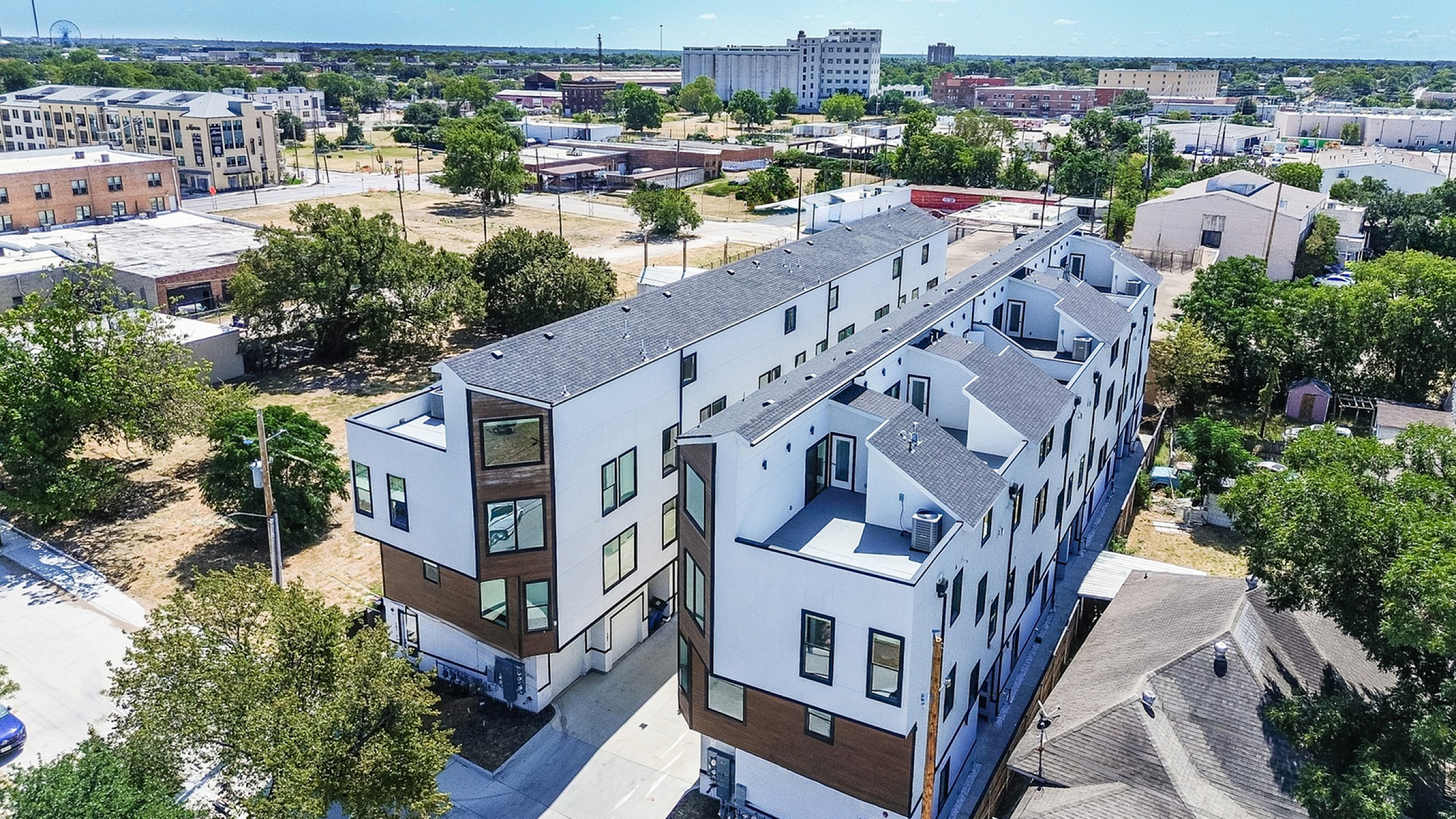 Modern multi-story apartment complex with sleek design and expansive urban views in a vibrant neighborhood.