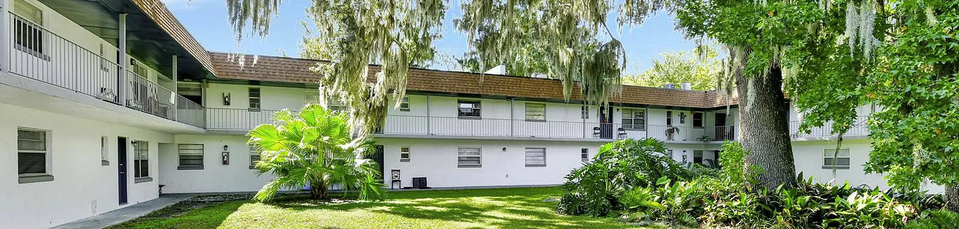 Picturesque courtyard with lush greenery and historic building.