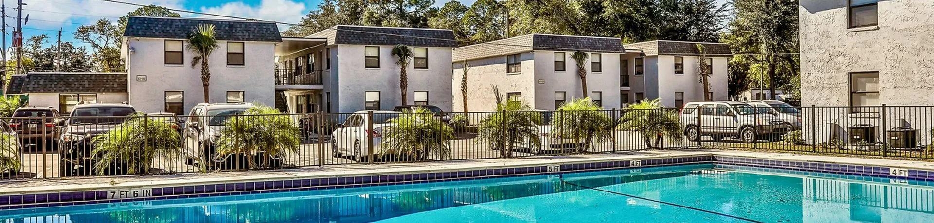 Inviting apartment complex with sparkling pool and lush greenery, offering a relaxing and vibrant community atmosphere.