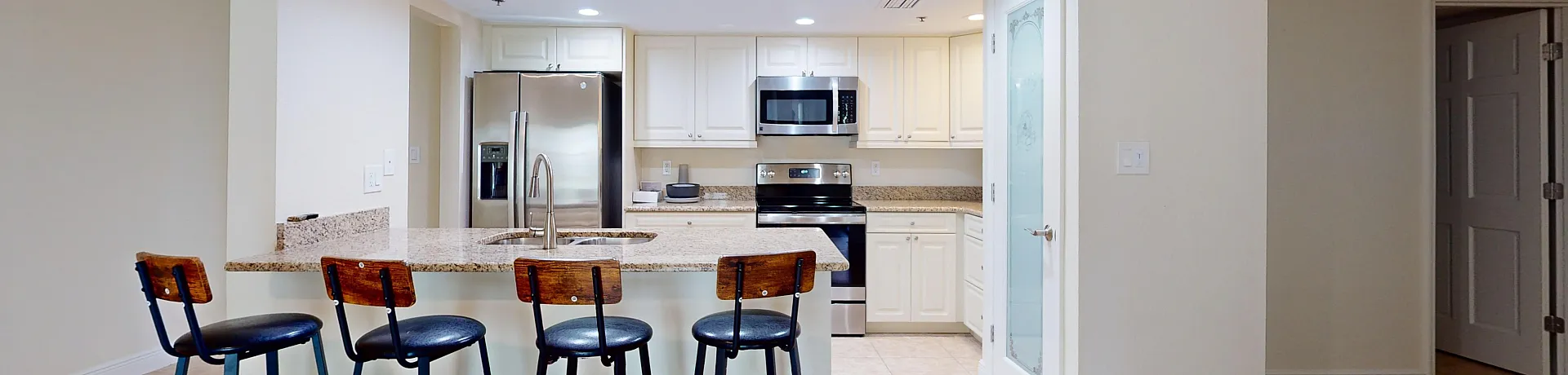 Contemporary open-concept kitchen with granite countertops, modern appliances, and inviting bar seating.