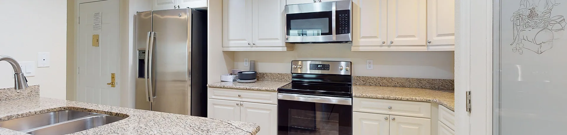 Elegant kitchen boasting granite countertops, modern stainless steel appliances, and custom white cabinetry for a sleek, contemporary look.