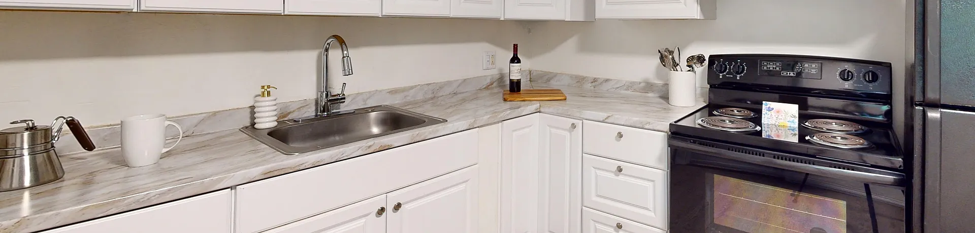Chic modern kitchen with elegant white cabinetry, sleek countertops, and stainless steel appliances, perfect for stylish and functional cooking.
