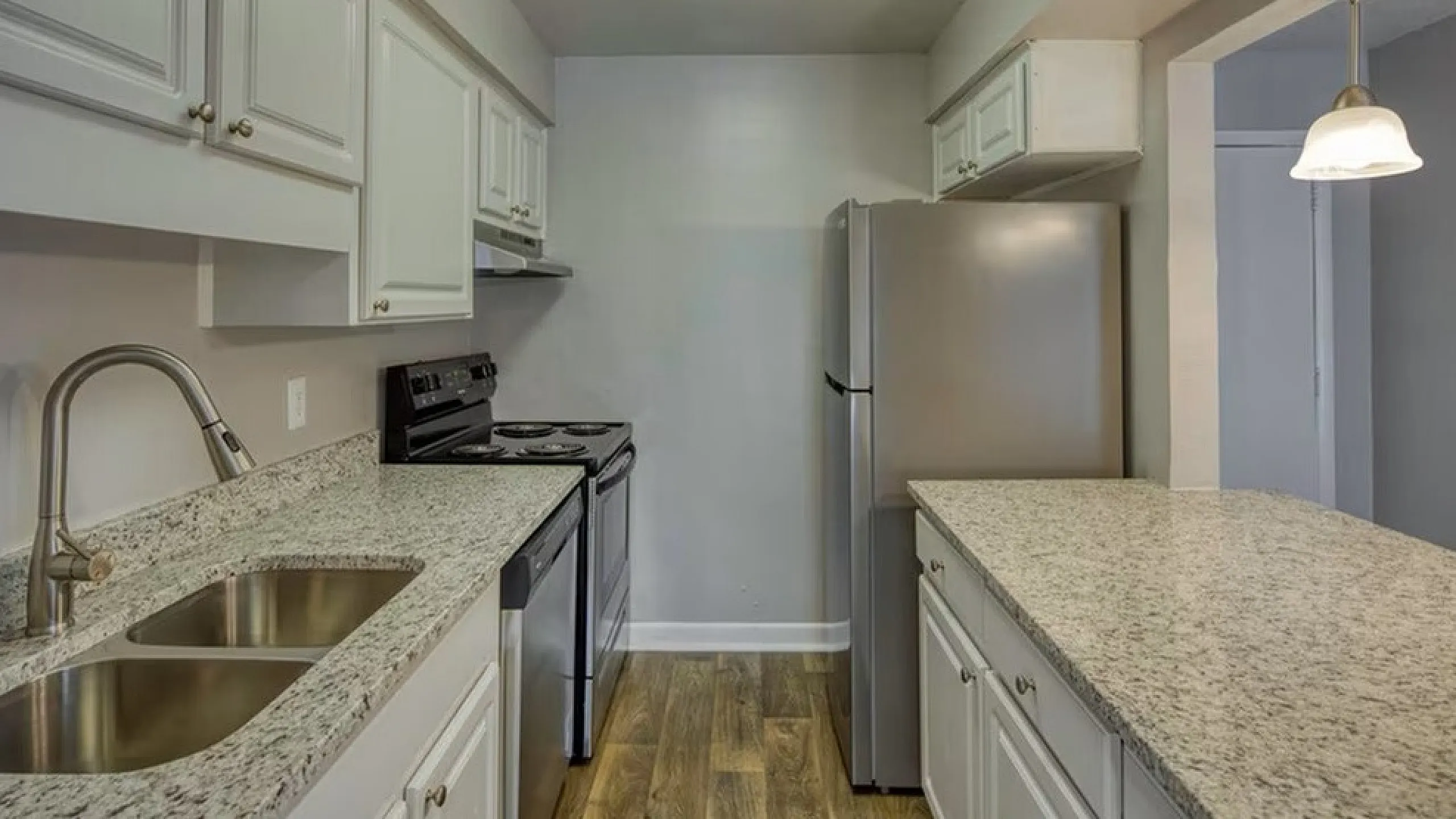 Modern kitchen with granite countertops, stainless steel appliances, and elegant cabinetry.