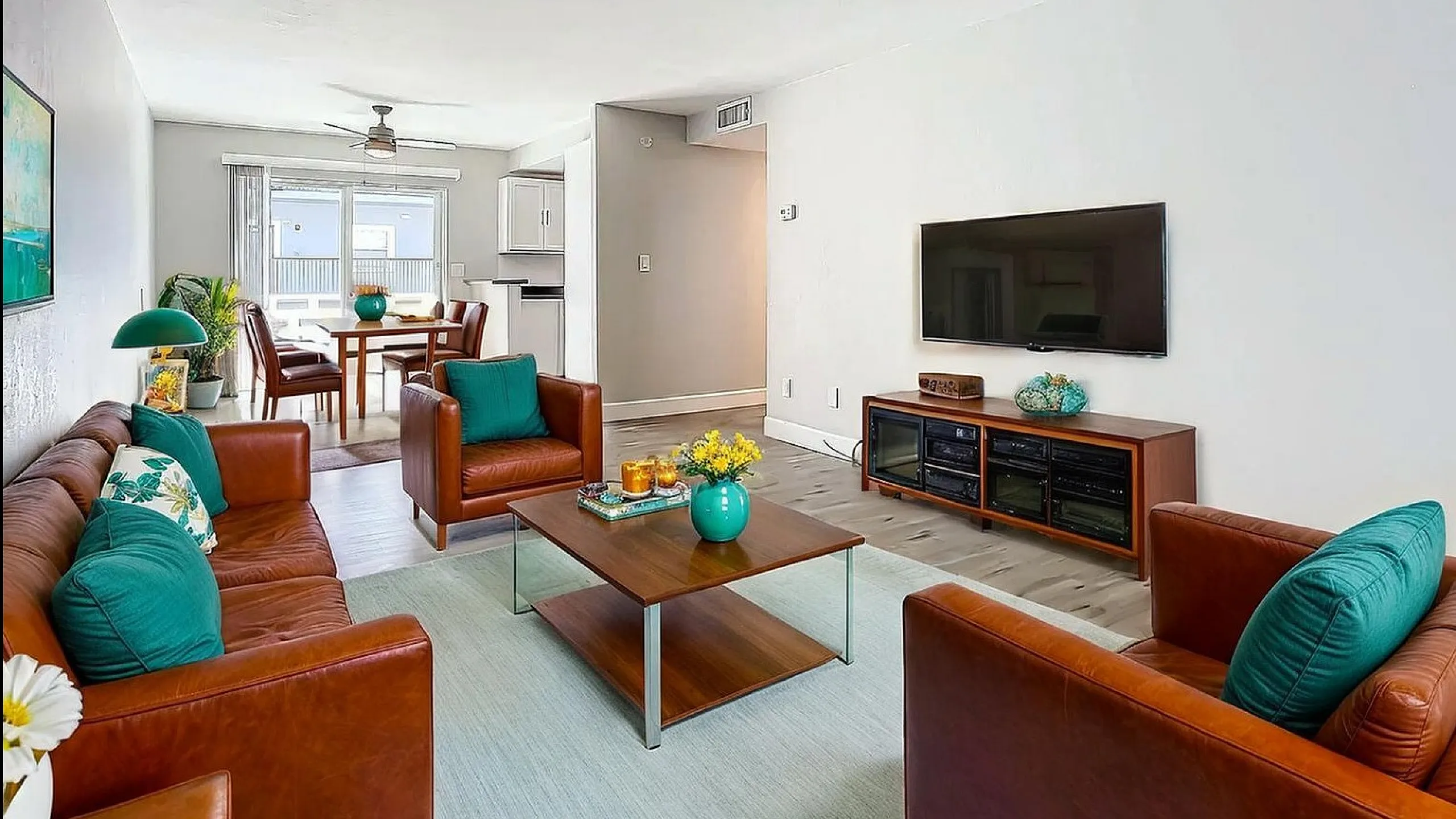 Modern living area featuring stylish leather seating, a chic coffee table, and an inviting dining space with natural light.