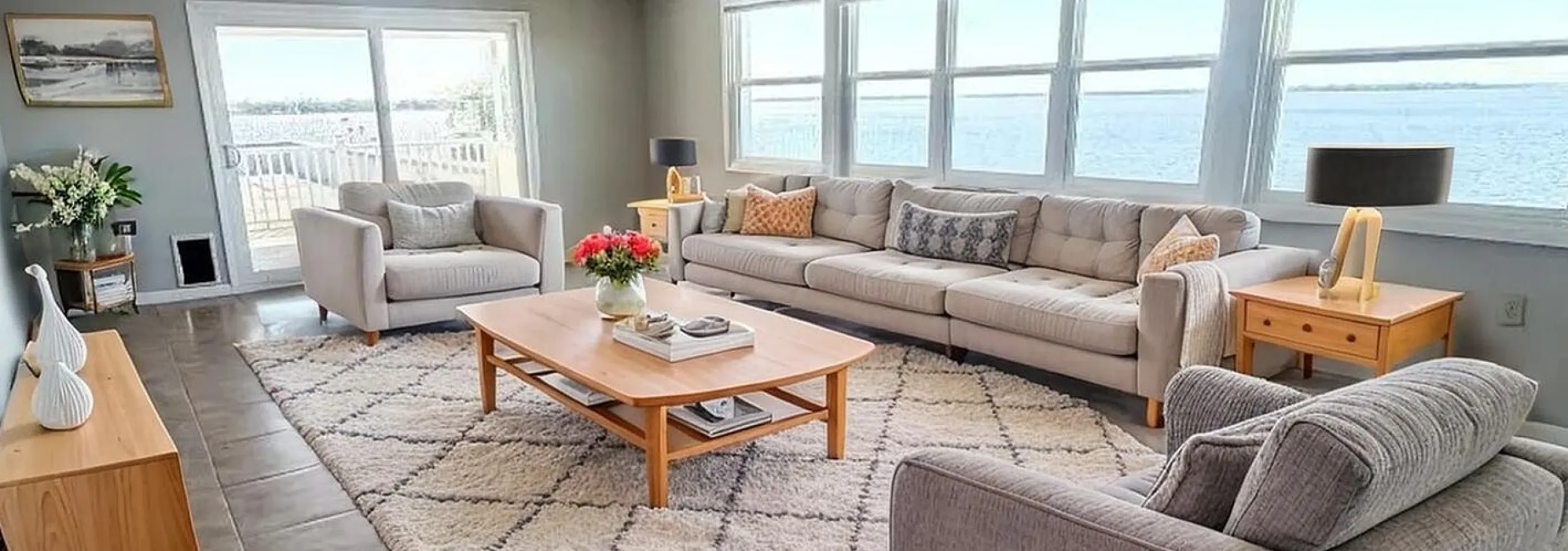 Spacious and inviting living room with plush sofas, large windows offering stunning ocean views, and a modern, elegant decor.