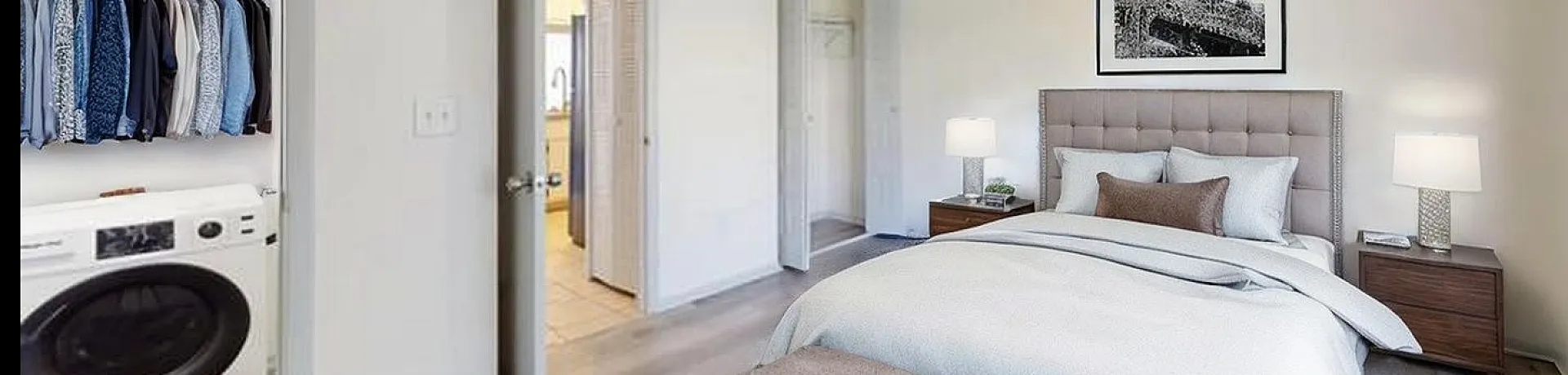 Inviting bedroom with modern decor, featuring a plush bed, stylish nightstands, and a walk-in closet with organized shelving and a convenient laundry area.