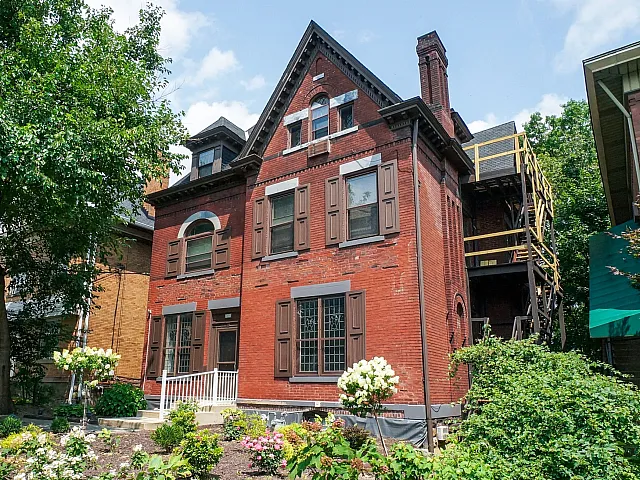 Captivating historic brick house with arched windows and a lush garden.