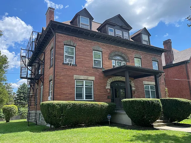 Beautiful historic brick house with manicured gardens and classic architectural details.