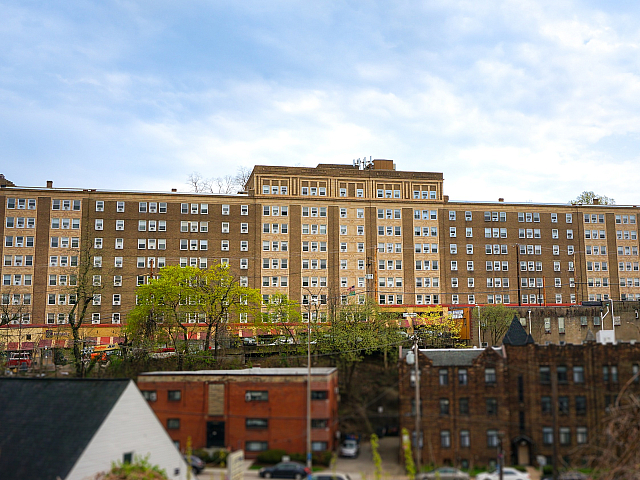 Charming multi-story apartment building with classic architecture, surrounded by lush greenery and a welcoming neighborhood appeal.