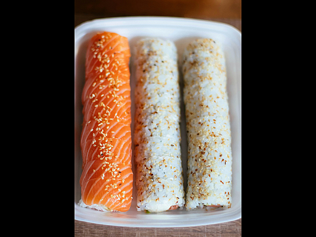 Vibrant sushi platter showcasing fresh salmon nigiri and sesame-topped maki rolls, perfect for sushi enthusiasts.