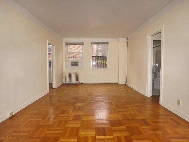 LeBaron unit living room, with cream walls and parquet hardwood flooring.