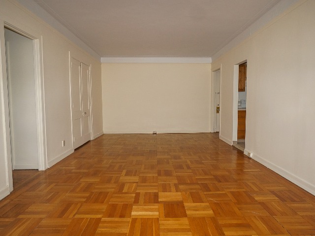LeBaron unit living room, with cream walls and parquet hardwood flooring.