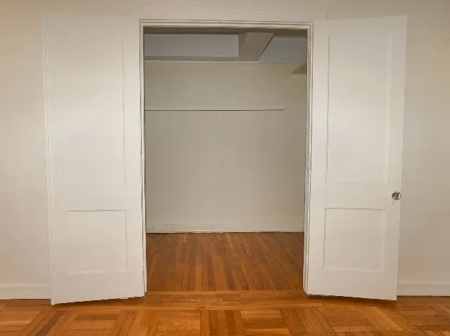 LeBaron unit dressing closet, with cream walls and parquet hardwood flooring.