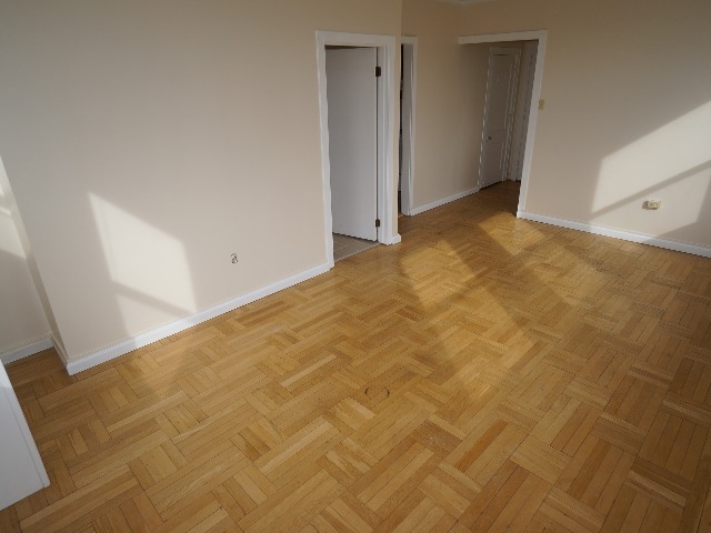 Artena unit showing living room with cream colored walls, and hardwood flooring.