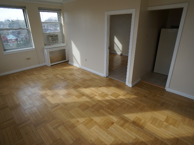 Artena unit showing living room with cream colored walls, and hardwood flooring.