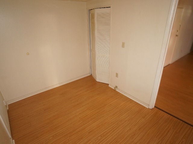 Talbot unit showing den with cream colored walls, and hardwood vinyl flooring.