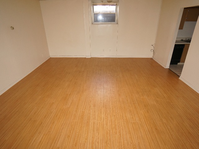 Talbot unit showing living room, with cream colored walls, and hardwood vinyl flooring.