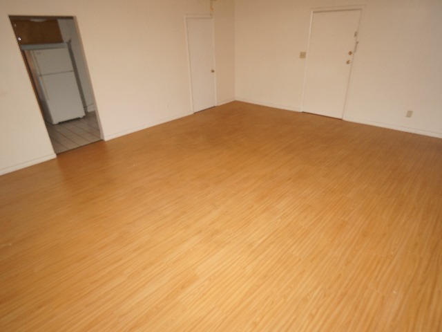 Talbot unit showing living room, with cream colored walls, and hardwood vinyl flooring.