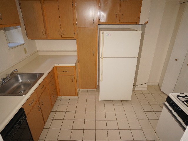 Talbot unit showing kitchen with cream colored walls, and cream colored tile flooring. Equipped with wooden cabinets, refrigerator, stove, oven, dishwasher, and sink.