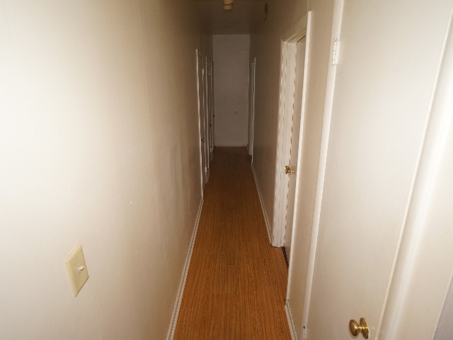 Talbot unit showing hallway with cream colored walls, and hardwood vinyl flooring.