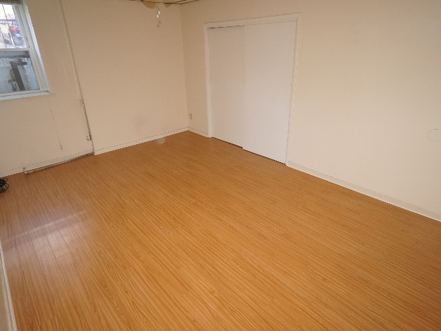 Talbot unit showing bedroom with cream colored walls, and hardwood vinyl flooring.