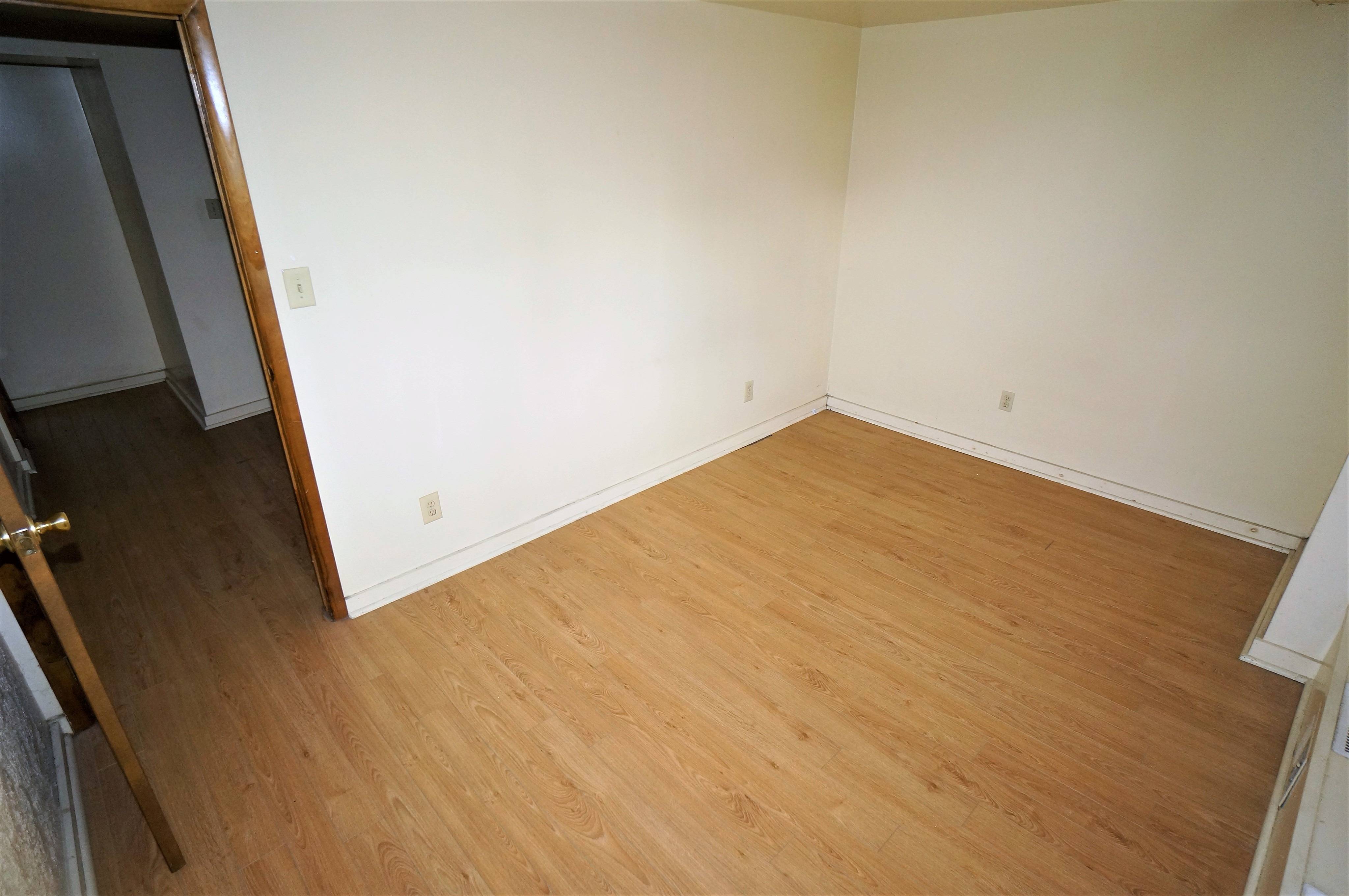 Bedroom angle shows door to the bedroom and far corner of the room