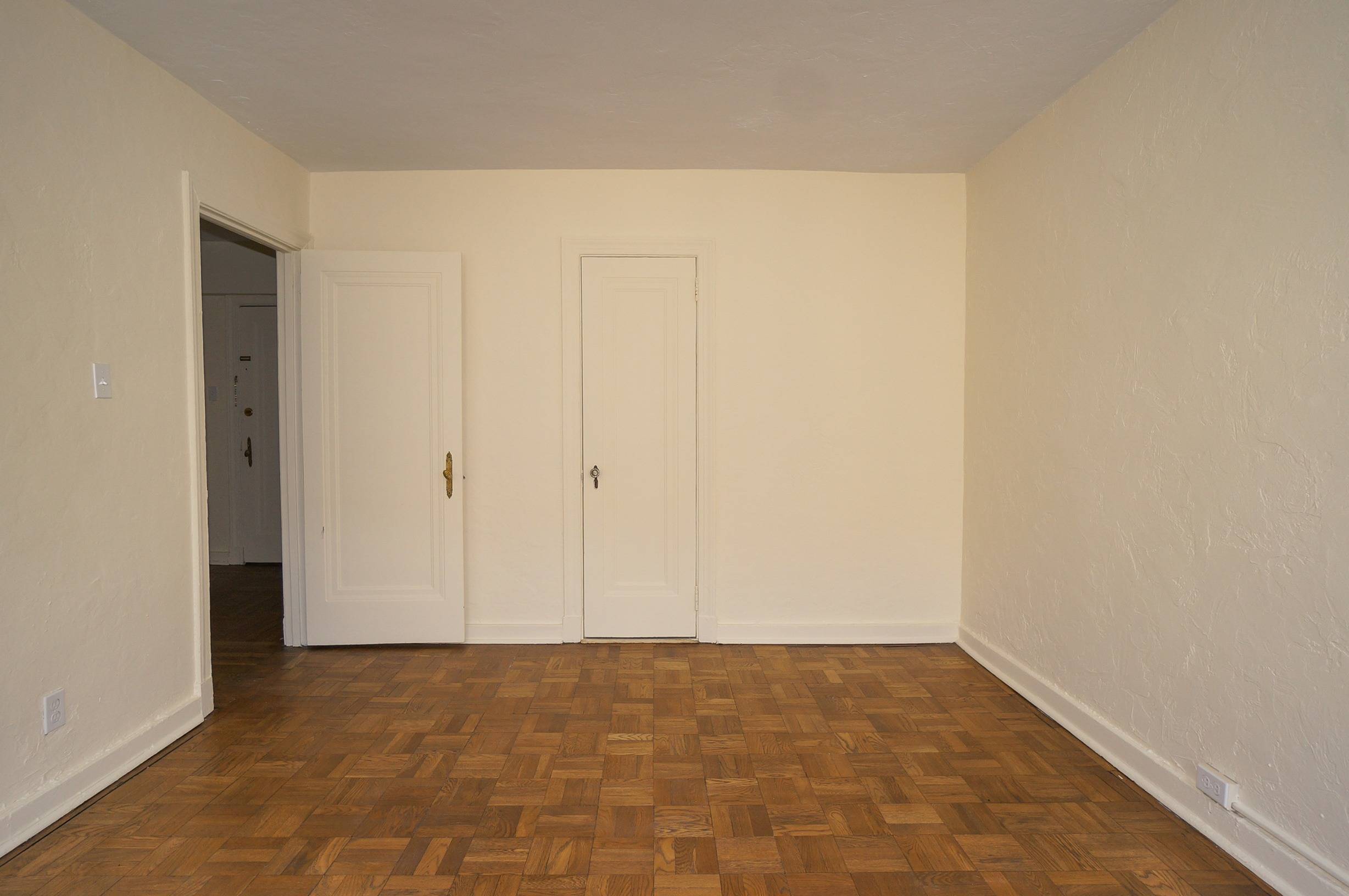 Bedroom  Angle shows bedroom door, closet door as well as wood floors and white walls