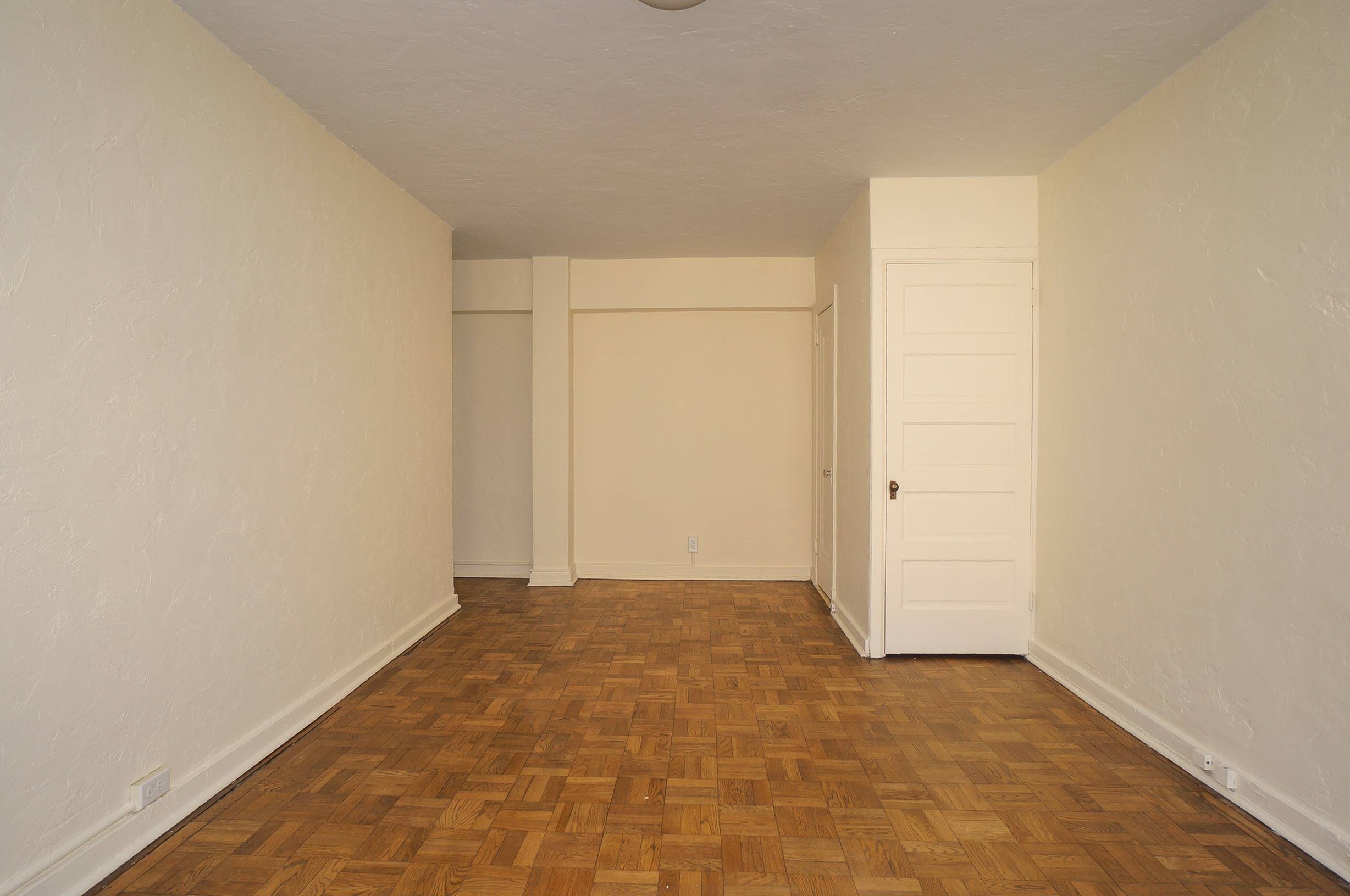 Bedroom angle shows bedroom door as well as closets