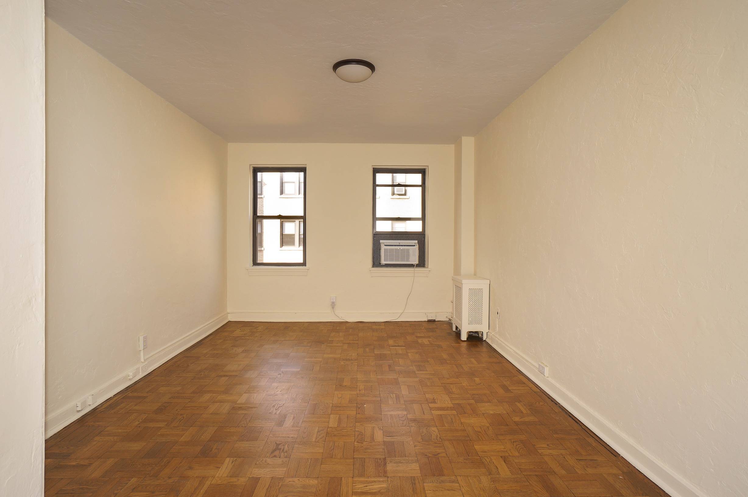 Bedroom shows windows, air conditioner and radiator.