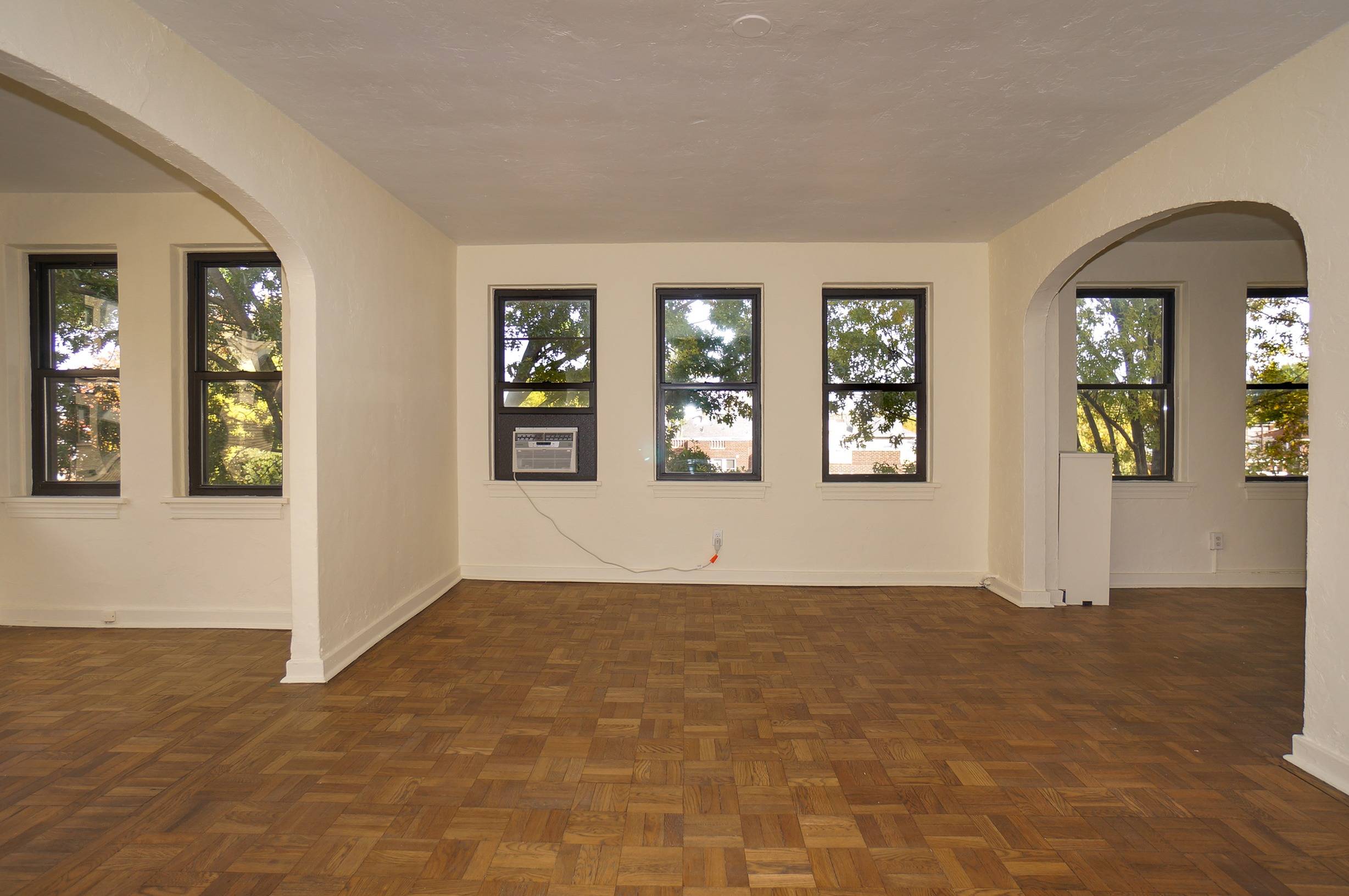 Living Room Angle shows sunroom and dining room entrances, windows, and an air conditioner.