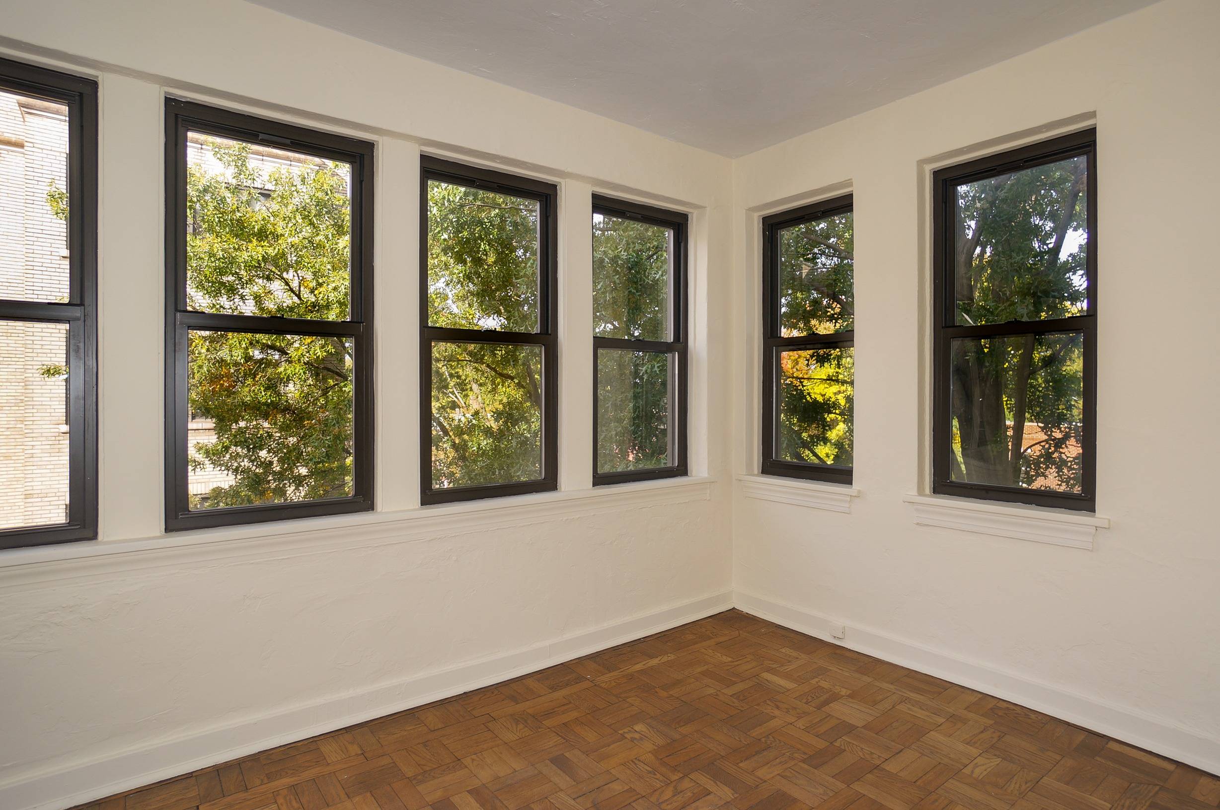 Sun Parloer shows windows white walls and wood floors