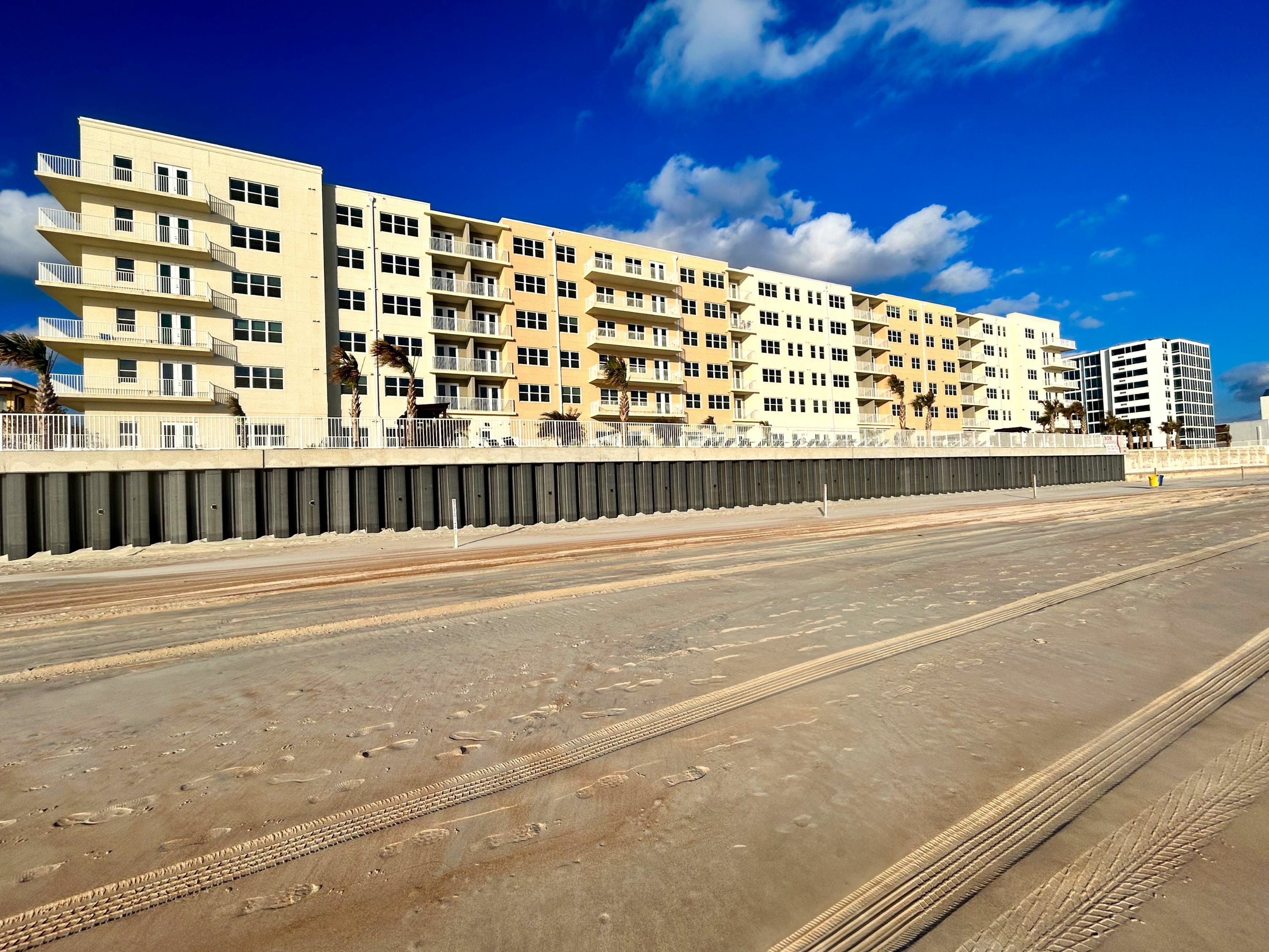 Luxurious beachfront apartment complex with stunning blue sky and ocean views.